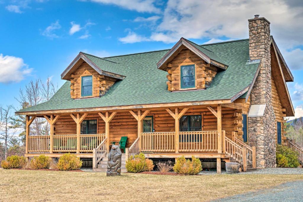 a large log cabin with a green roof at Charming Cabin with Deck, 10 Min to Bretton Woods! in Carroll