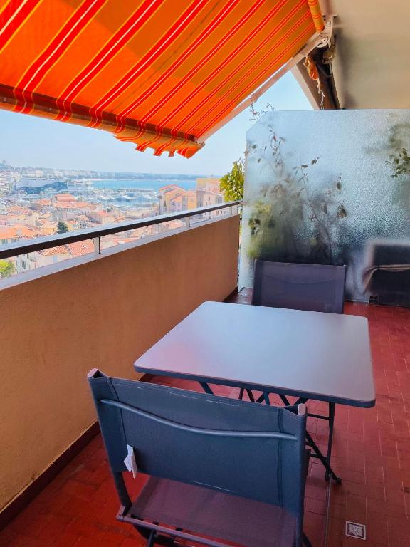 une table et des chaises sur un balcon avec vue dans l'établissement Le Suquetan, à Cannes