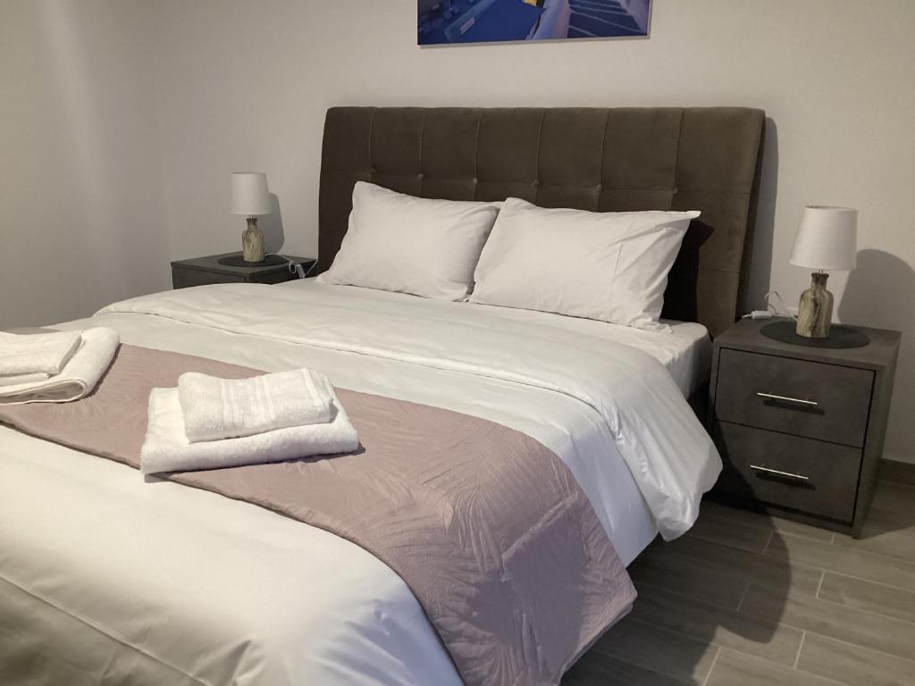 sypialnia z dużym białym łóżkiem z 2 stolikami nocnymi w obiekcie Zoi Studios w mieście Kastrópoulon