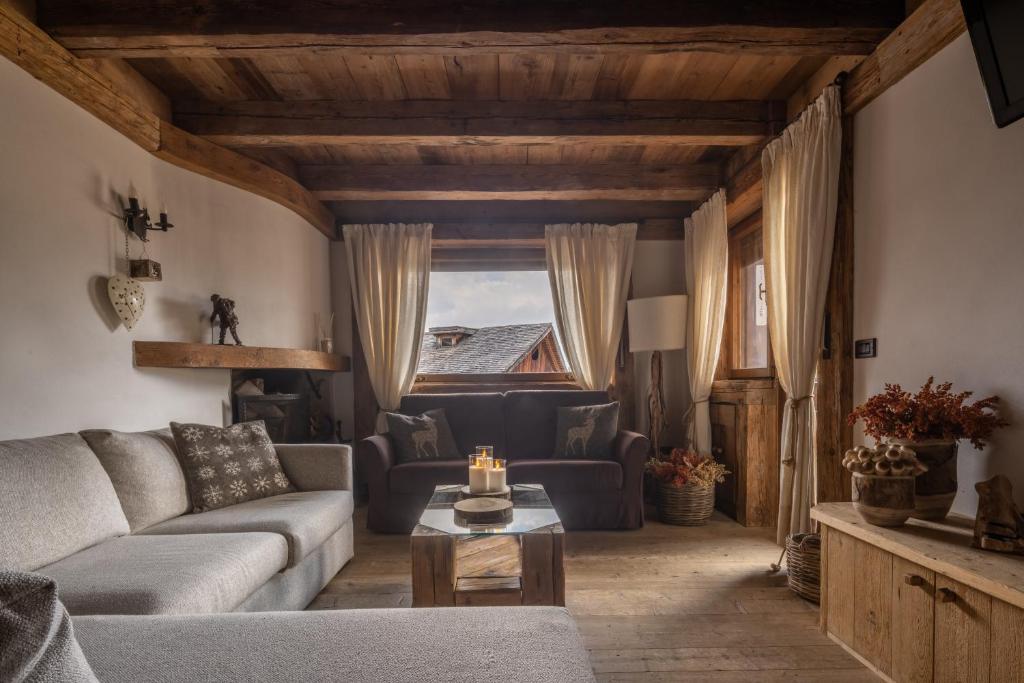 ein Wohnzimmer mit einem Sofa und einem Tisch in der Unterkunft Cortina Lodge Stunning View R&R in Cortina d'Ampezzo
