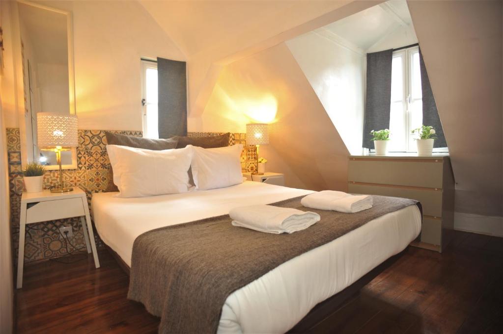 リスボンにあるSantos - Upper Loft with River Viewのベッドルーム1室(大型ベッド1台、タオル2枚付)