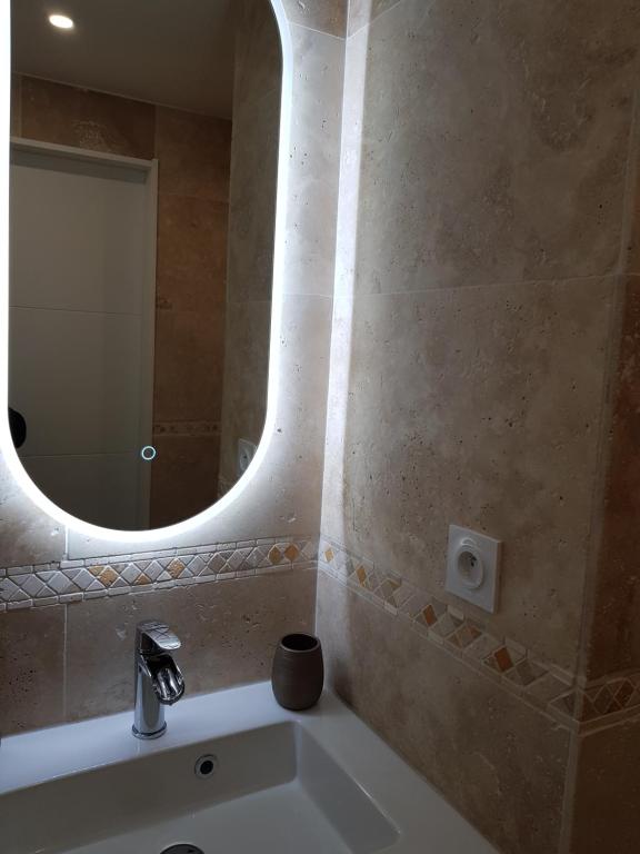 a bathroom with a sink and a mirror at Appartement en bord de mer in Cannes