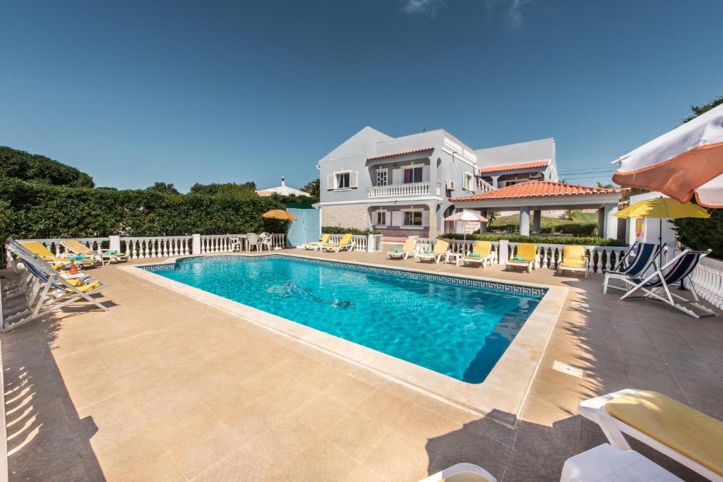 a swimming pool in front of a house at Villa Cadre in Armação de Pêra