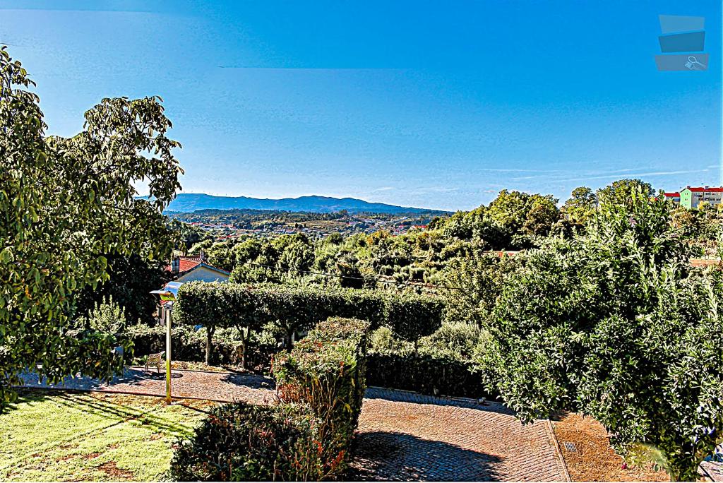 Blick auf einen Garten mit Bäumen und Bergen in der Unterkunft Quinta de Marzovelos in Viseu
