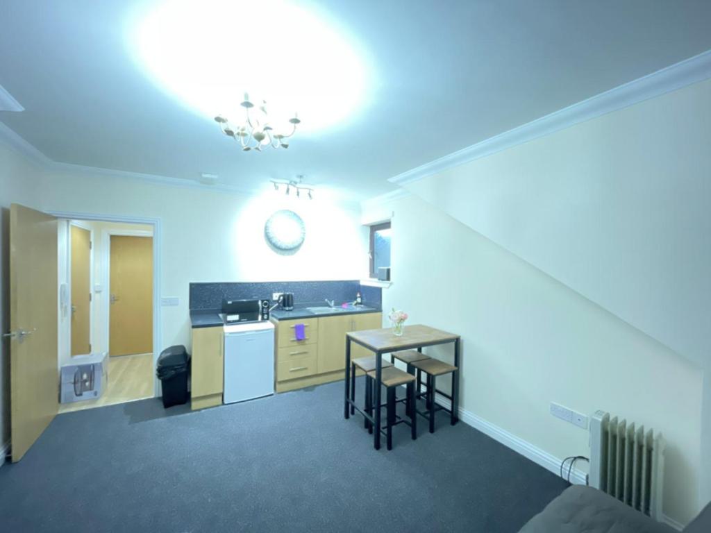 a room with a kitchen with a table and a sink at Ben View Apartments Flat A in Caol