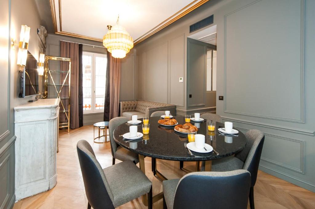 Pick A Flat's Champs Elysees Apartments - Rue Lincoln في باريس: غرفة طعام مع طاولة وكراسي