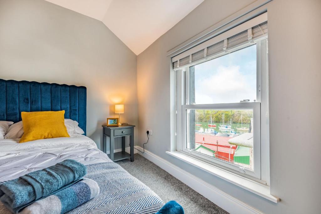 sypialnia z łóżkiem i dużym oknem w obiekcie 4 Segontium Terrace w mieście Caernarfon