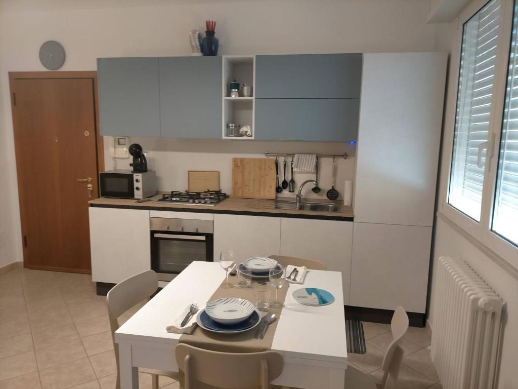 cocina con mesa, sillas y mesa blancas en appartamento incantevole a due passi dal mare a Viserbella vicino fiera Rimini en Rímini