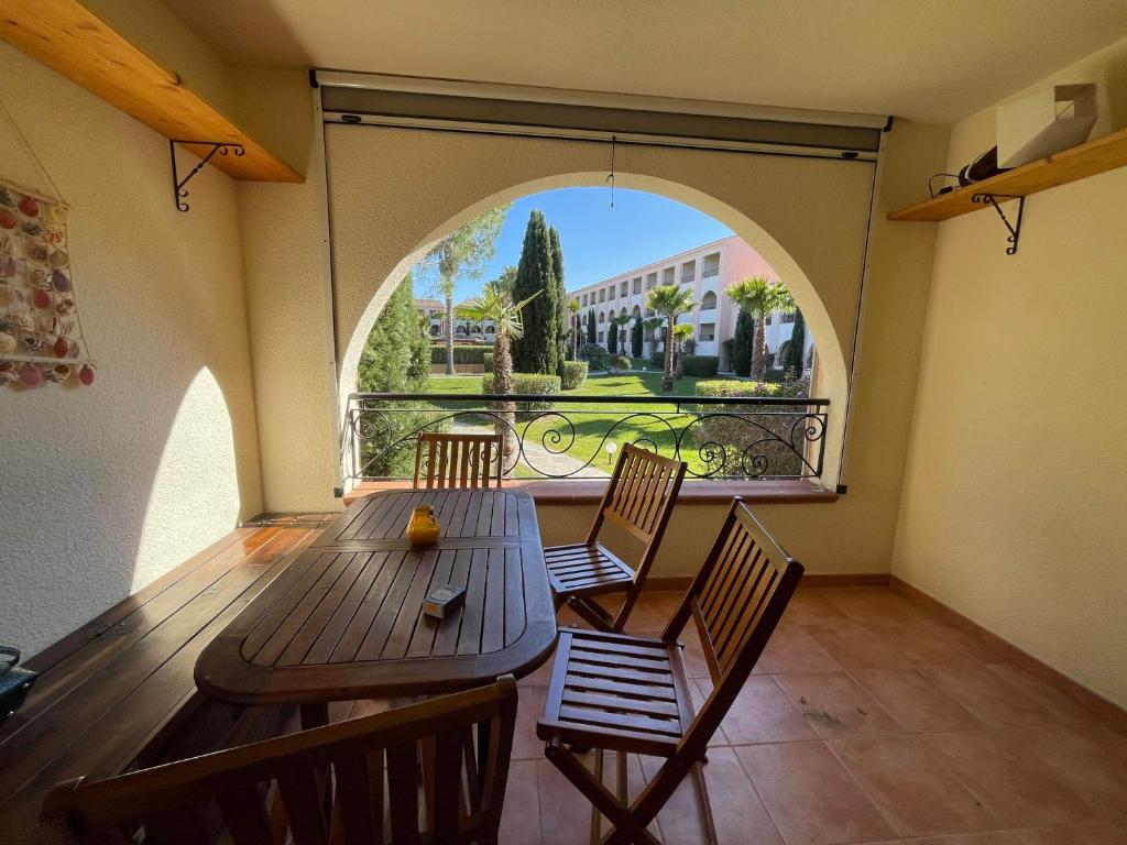 une pièce avec une table et des chaises et une grande fenêtre dans l'établissement Résidence marine de bravone Accès plage, Piscine, à Linguizzetta