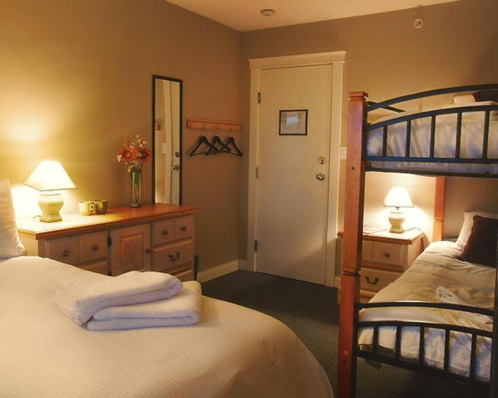 a bedroom with a bed and a bunk bed with a mirror at Painted Turtle Guesthouse in Nanaimo