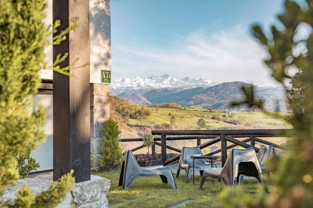 un grupo de sillas y una mesa con montañas en el fondo en Apartamentos Picabel, en Cangas de Onís