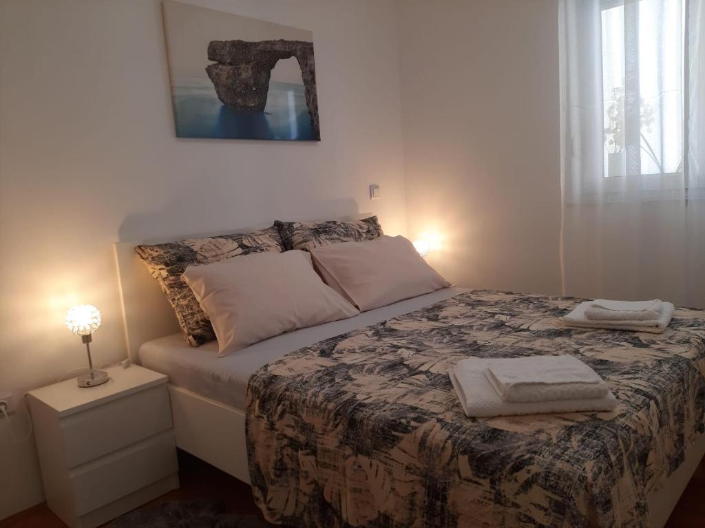 a bedroom with a bed with two towels on it at Apartman Sky in Pula