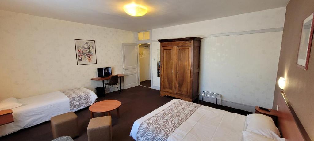 a hotel room with two beds and a desk at Nouvel Hotel in Lons-le-Saunier