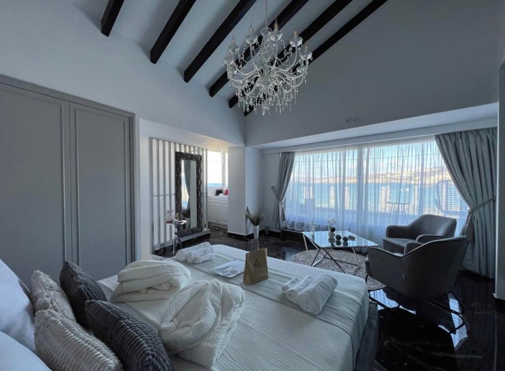 sypialnia z dużym łóżkiem i żyrandolem w obiekcie Mare suites 1 w Chanii