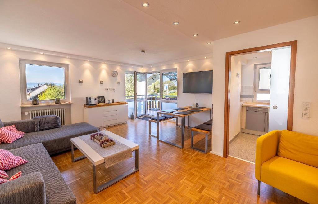 een woonkamer met een bank en een tafel bij Ferienwohnung Seeblick mit Blick auf die Alpen in Wasserburg