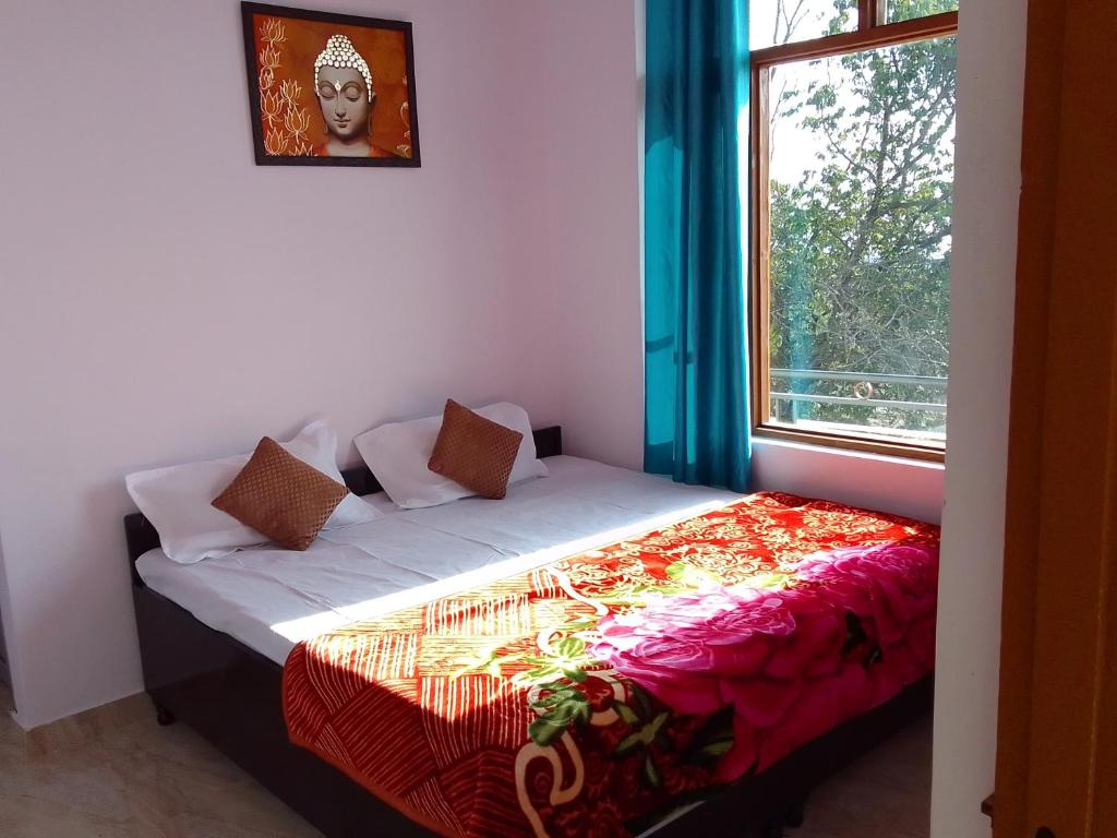 a bedroom with a bed with a window at Samaira home stay in Bīr