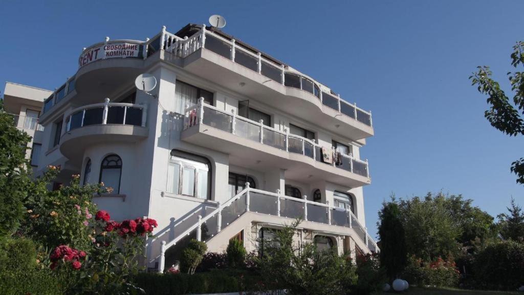 a white apartment building with balconies and flowers at Къща за гости АЛЛА in Byala