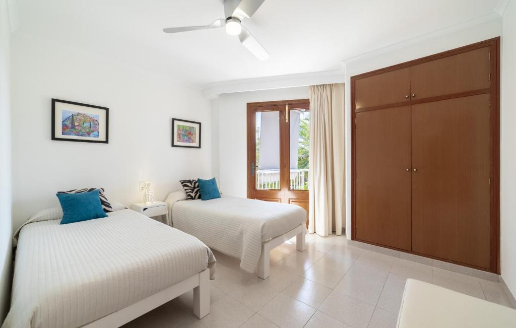 Habitación blanca con 2 camas y armario en Record Maritim II, en Puerto de Alcudia