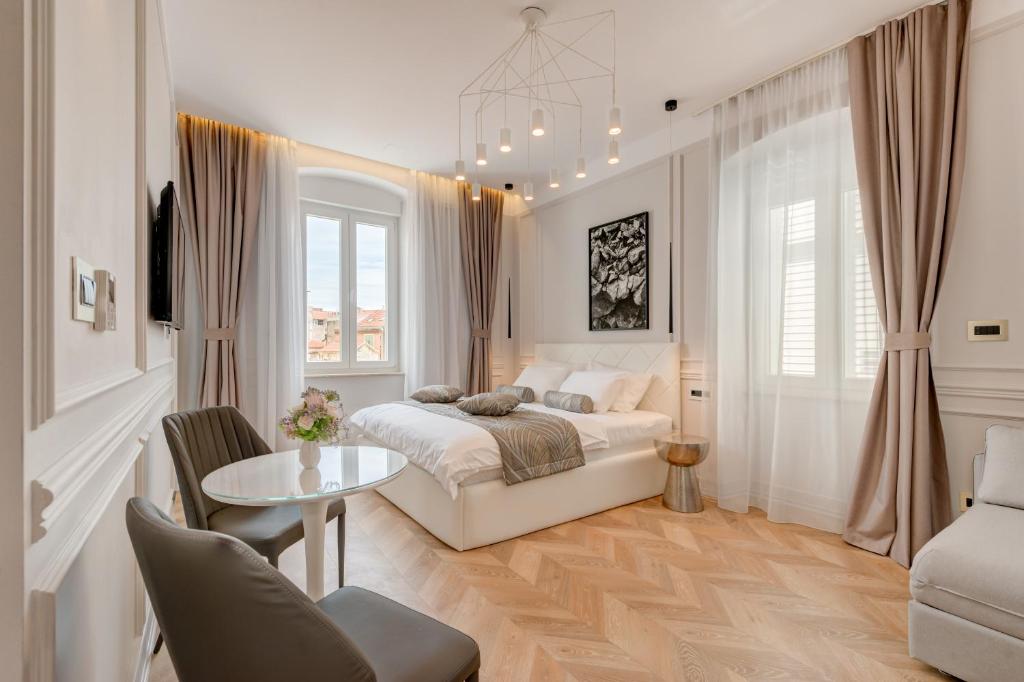 a bedroom with a bed and a table and chairs at Luxury Rooms L'Avenue 2 Split in Split