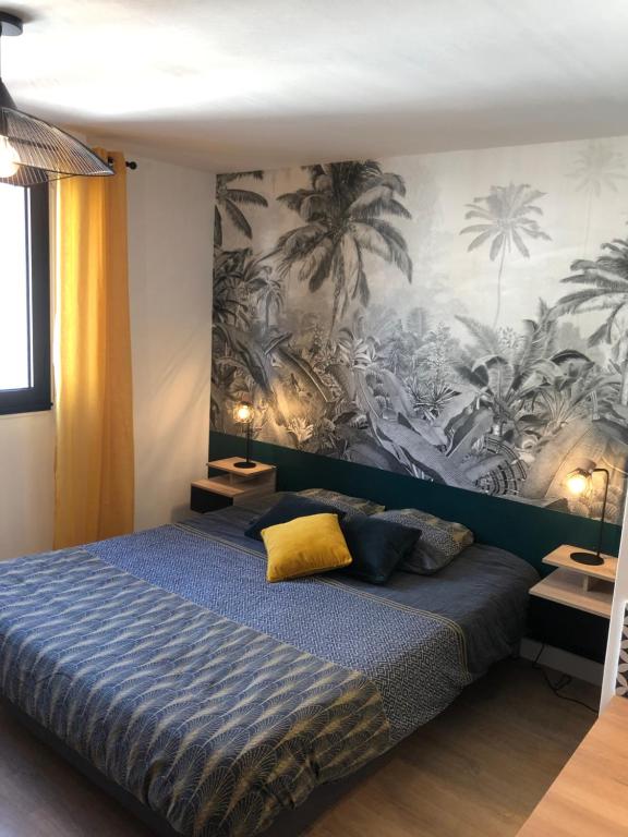 a bedroom with a blue bed with a mural of palm trees at Concarneau centre-ville proche plage in Concarneau