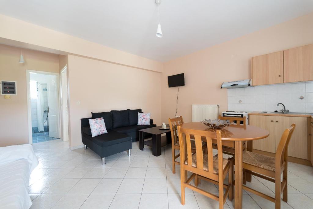 een keuken en een woonkamer met een tafel en een bank bij SPIROS HOME in Lixouri