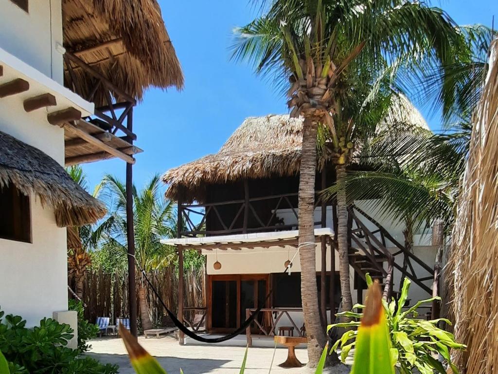 un complejo con techo de paja y palmeras en Casa Sofia Holbox, en Isla Holbox