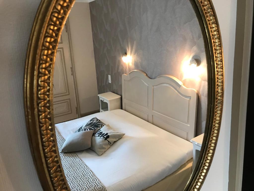 Postel nebo postele na pokoji v ubytování Hôtel Les Deux Magots