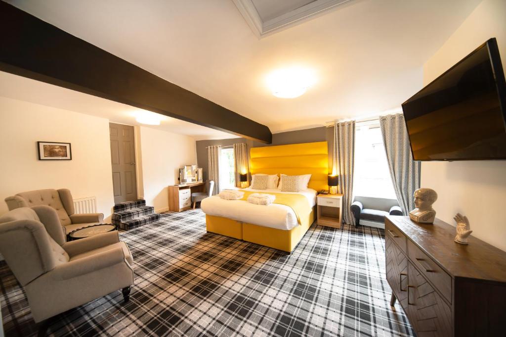 una camera d'albergo con letto, divano e sedia di The Kirkfield Hotel a Newton-le-Willows