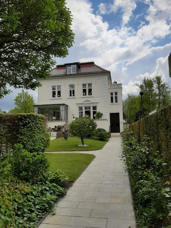 a white house with a walkway in front of it at Appartment Obergeschoß in Bad Zwischenahn