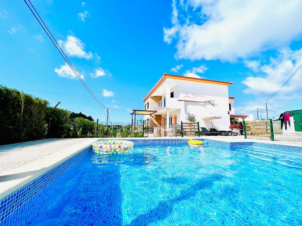 a villa with a swimming pool in front of a house at Oceantree Villa in Peniche