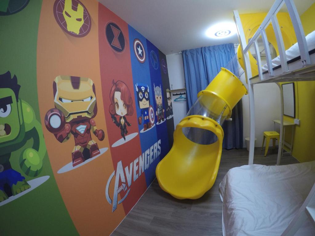 a childs bedroom with a superhero themed wall at CoCo Guesthouse Kemaman in Cukai