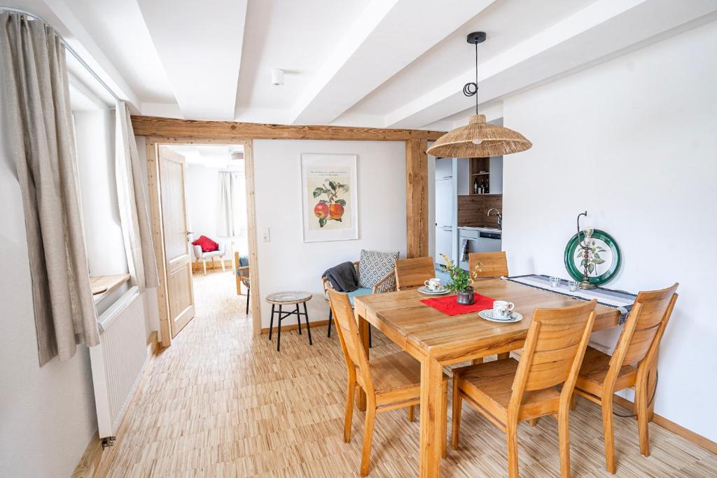 a kitchen and dining room with a wooden table and chairs at Gästehaus Großhöchberg in Spiegelberg