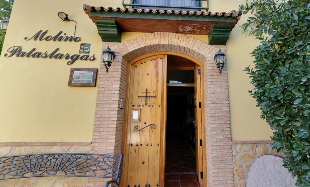 uma entrada para um edifício com uma porta de madeira em Casa rural Molino Pataslargas em Cotillas