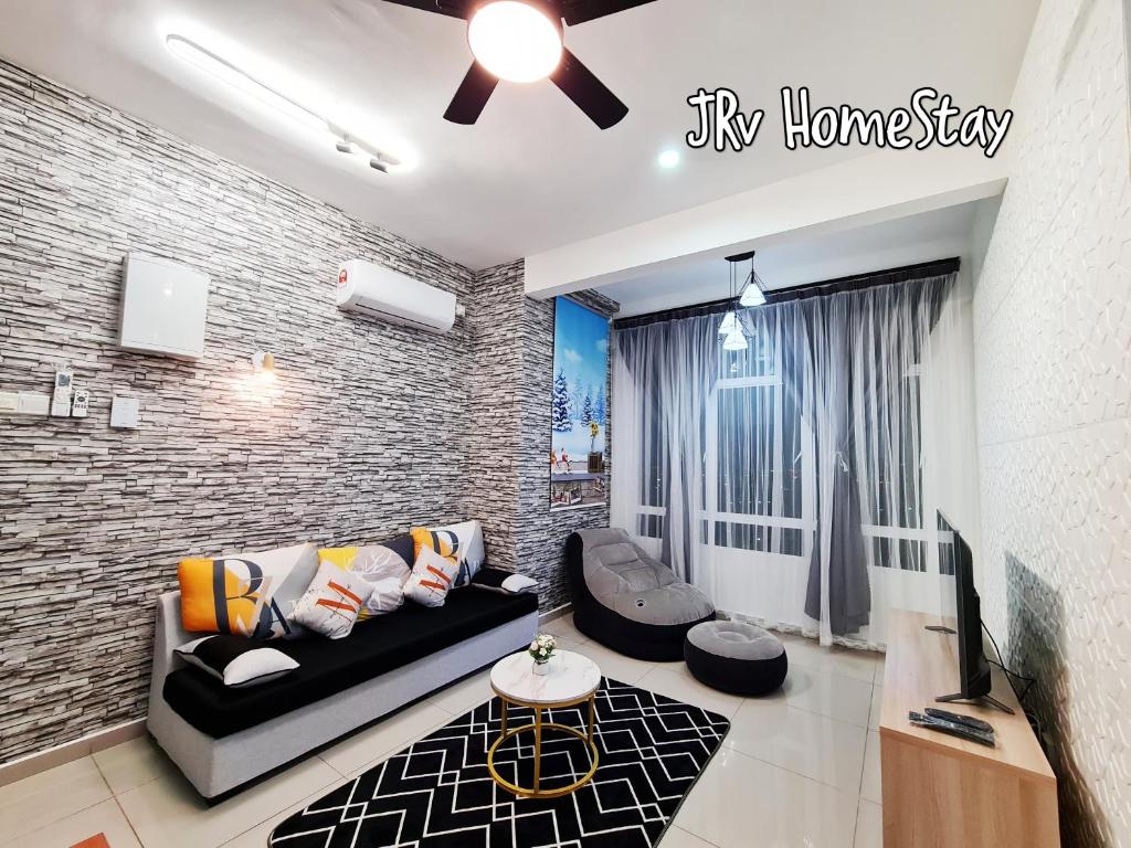a living room with a couch and a tv at JRv HotelStyle HomeStay Melaka in Melaka