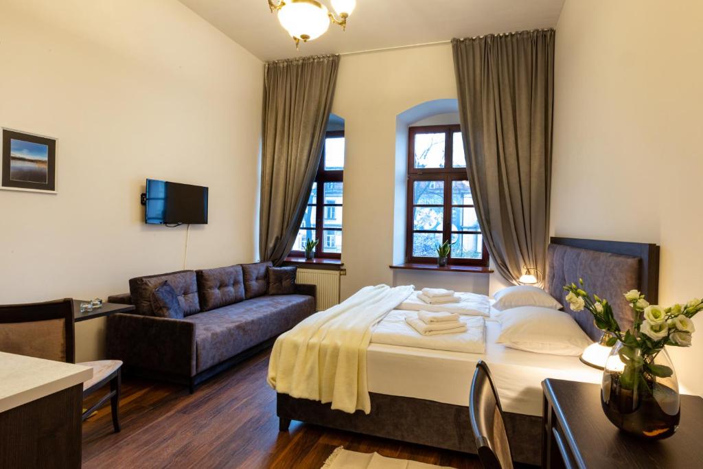 a hotel room with a bed and a couch at ZEPPELIN APARTMENTS Simple Acomodation in Jelenia Góra