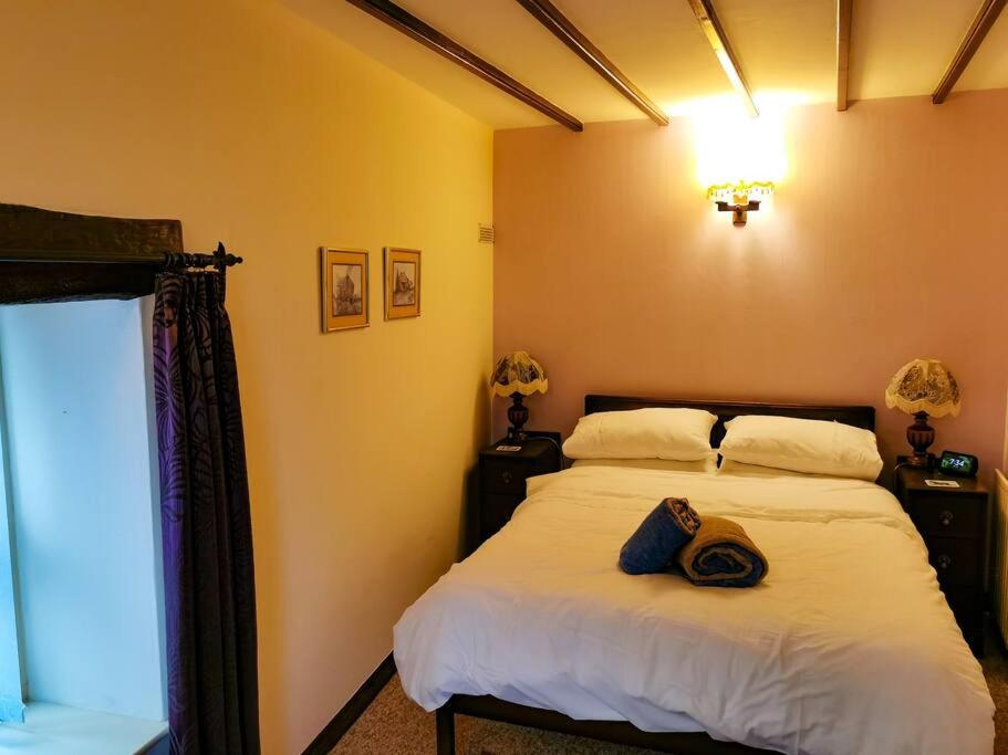 a bedroom with a bed with a hat on it at Stonecroft Cottage in Middleham