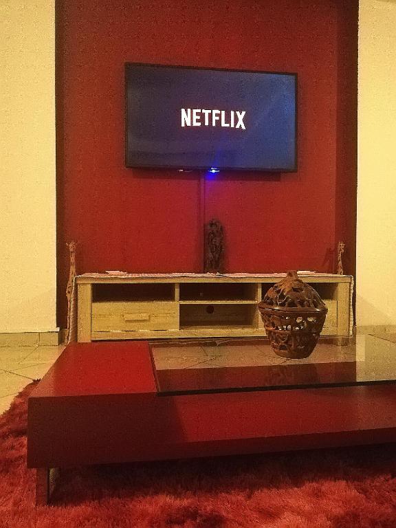 a living room with a television on a red wall at A Beach Condo in Durban