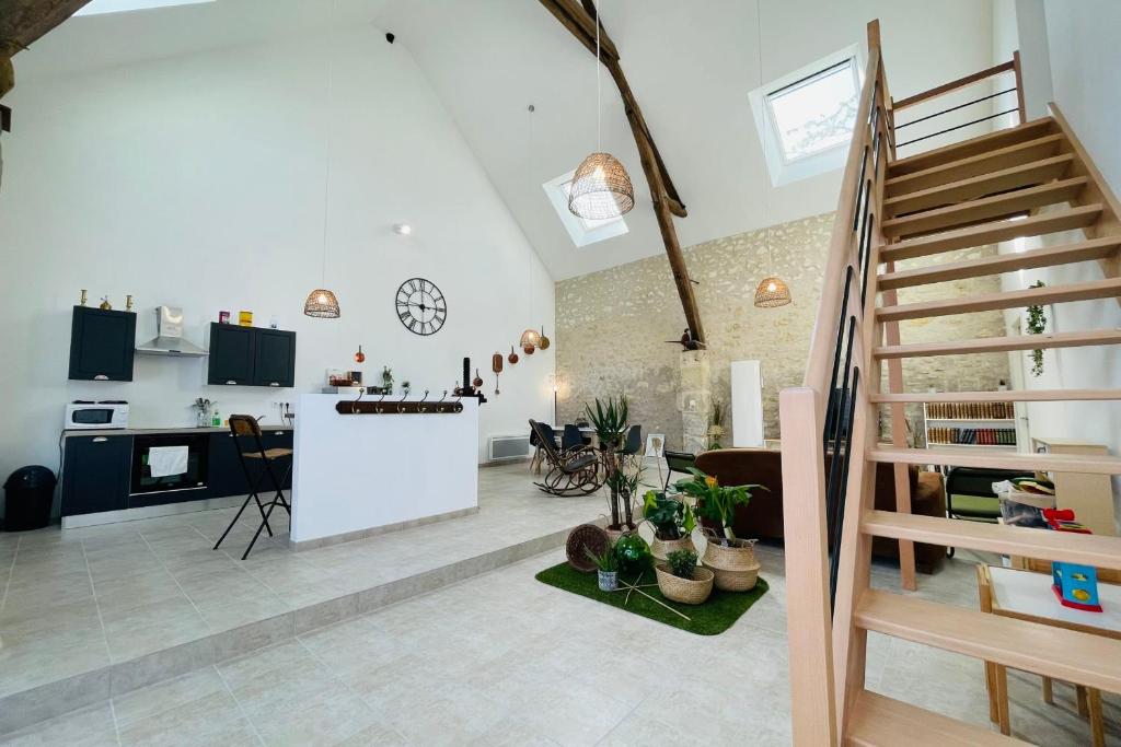 a kitchen and living room with a spiral staircase in a loft at La Grange de Lucé authenticité et douceur Amboisienne in Amboise