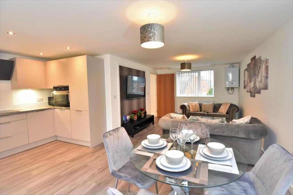 a kitchen and a living room with a table and chairs at Exec 2Bed 2Bath Serviced Apartment Balcony Parking in Milton Keynes