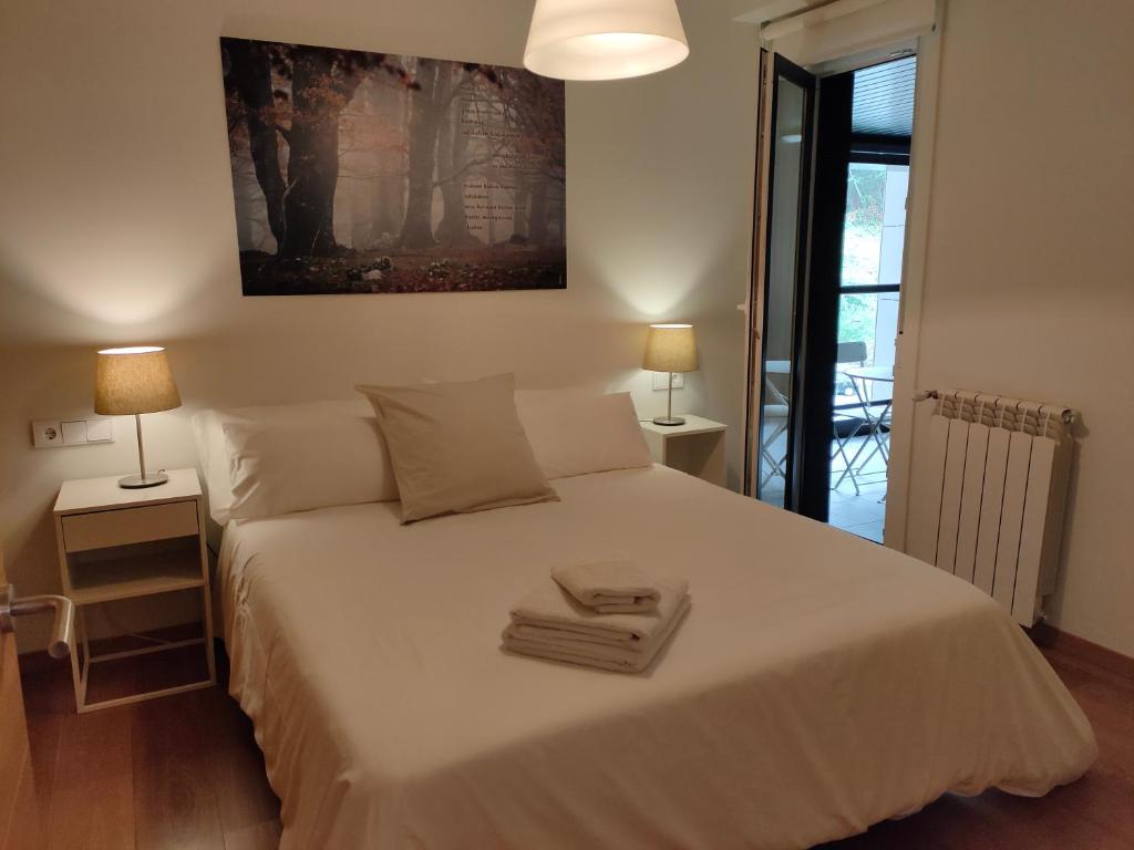 1 dormitorio con 1 cama blanca grande y 2 lámparas en Ventura Apartment ESS02622, en San Sebastián