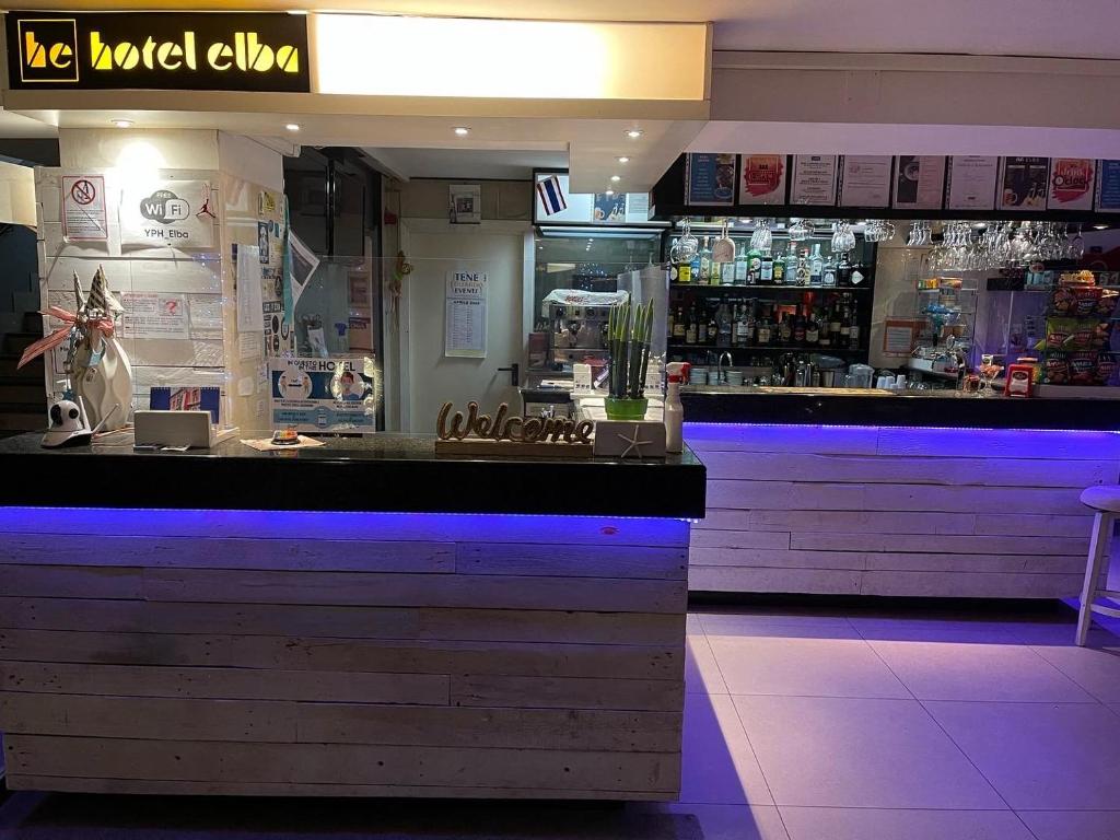 un ristorante con bar con luci blu di Hotel Elba a Rimini