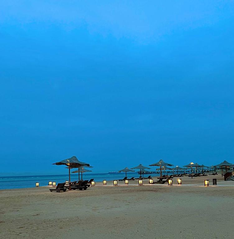 a group of umbrellas and chairs on a beach at Chalet in La Jolie Marina El Ain El Sokhna - Egyptian Families Only in Ain Sokhna