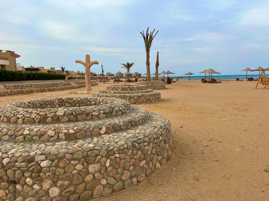 a row of rocks with a cross on a beach at Chalet in La Jolie Marina El Ain El Sokhna - Egyptian Families Only in Ain Sokhna