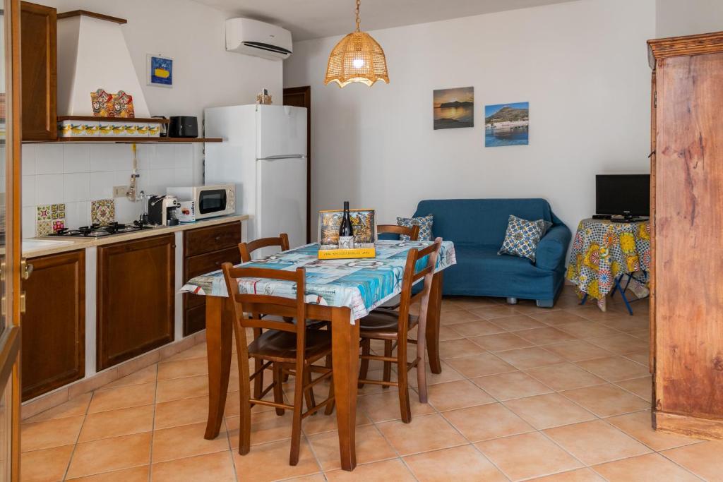 una cucina e una sala da pranzo con tavolo e sedie di Appartamento SEGESTA a Favignana