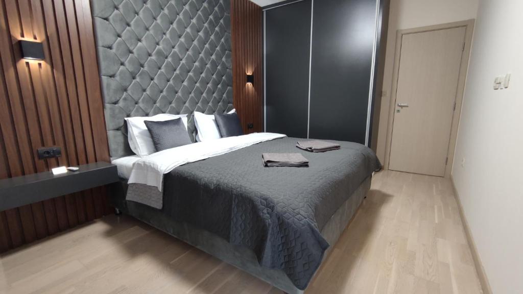 una camera da letto con un grande letto con una grande testiera di Harmony Apartments a Podgorica