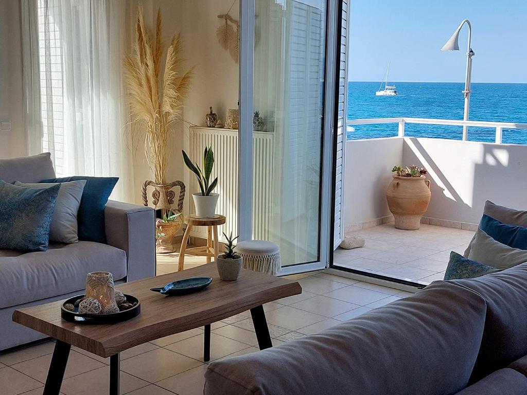 a living room with a couch and a table at Amazing Beachfront Apartment in Hersonissos in Hersonissos