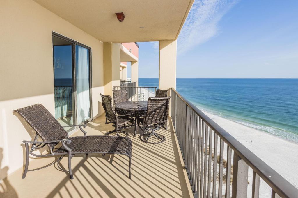 Un balcón con sillas, una mesa y el océano en Phoenix V 1512, en Orange Beach