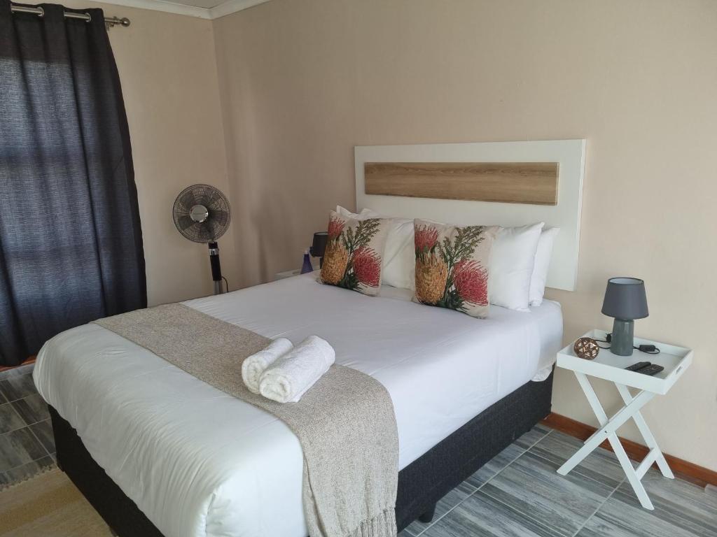 Un dormitorio con una gran cama blanca con almohadas. en Ribeng la Noka Conference and Leisure Center, en Ga-Ramokadi-kadi