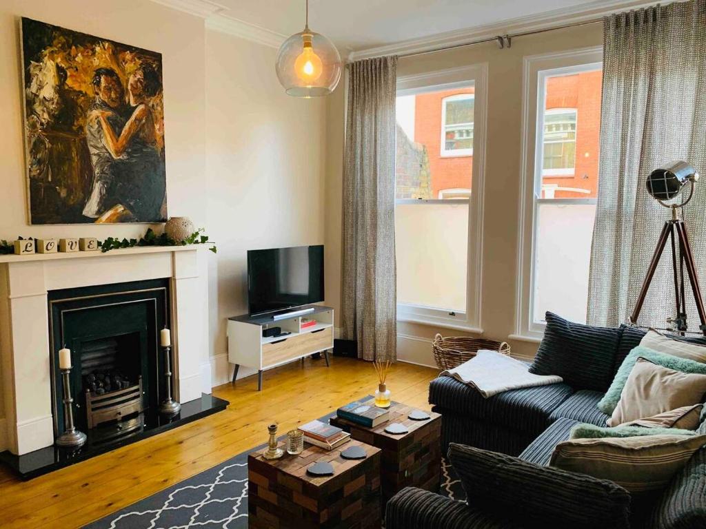 a living room with a couch and a fireplace at Luxury Fulham Flat with 5* touches nr River Thames in London