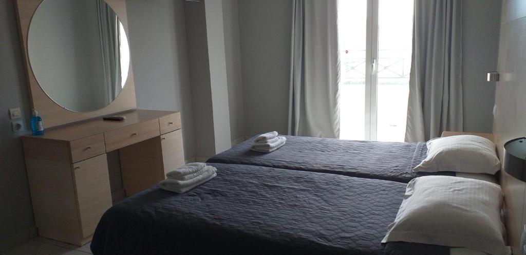 een slaapkamer met een bed met een spiegel en een wastafel bij Alexandros Studios Moraitika in Moraitika